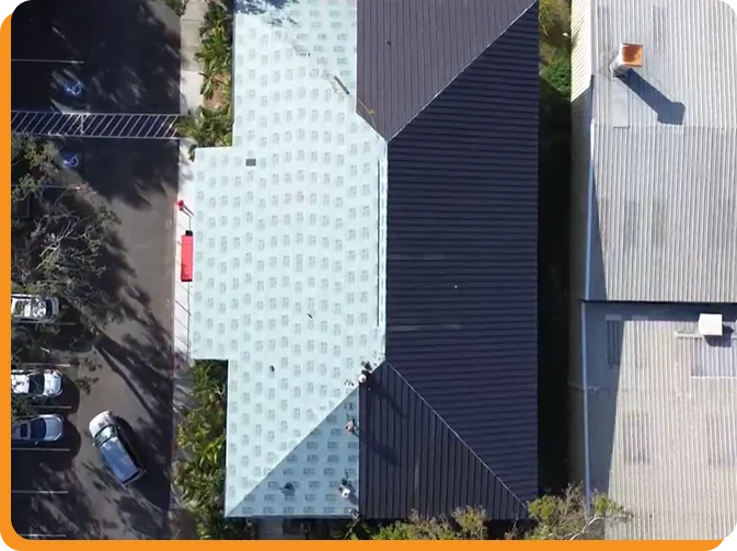 Commercial roofing contractor inspecting a flat roof in Tampa, Florida with city skyline, roofing materials, and storm-ready commercial building exterior.